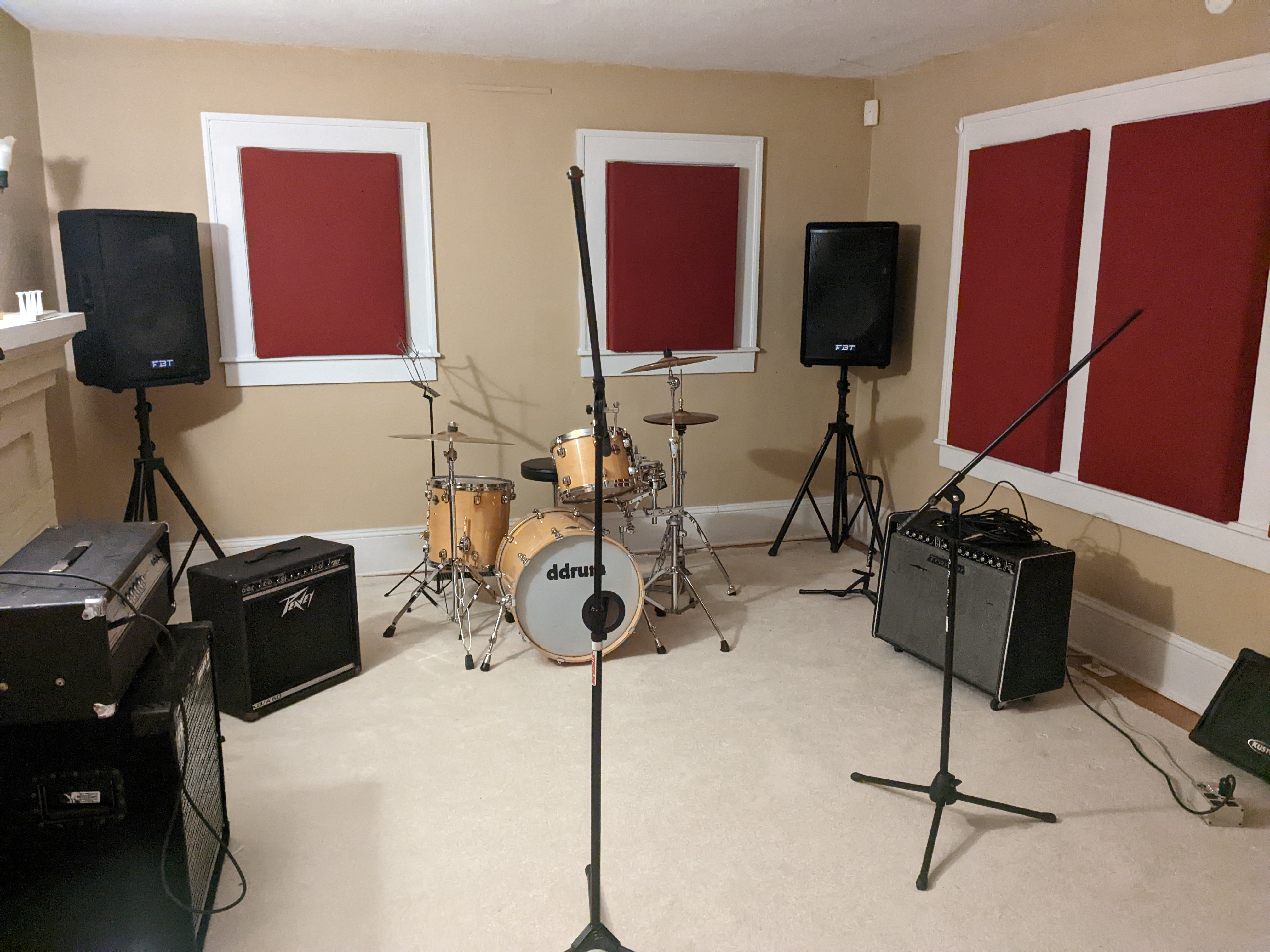 Interior of the Lunar room, which includes a drum kit, mic stand, and amplifiers. 